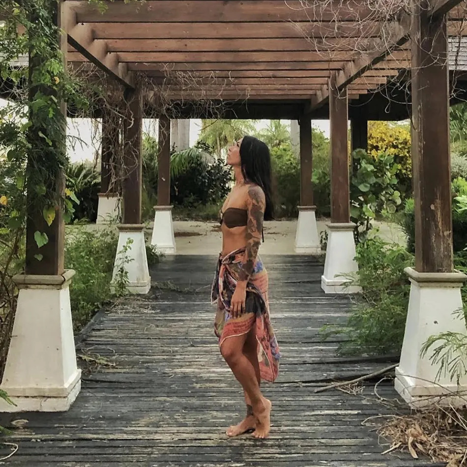 Francesca, fondatrice di Nomadyae, scalza in una pergola di legno, gonna bohémien, durante uno dei suoi viaggi.